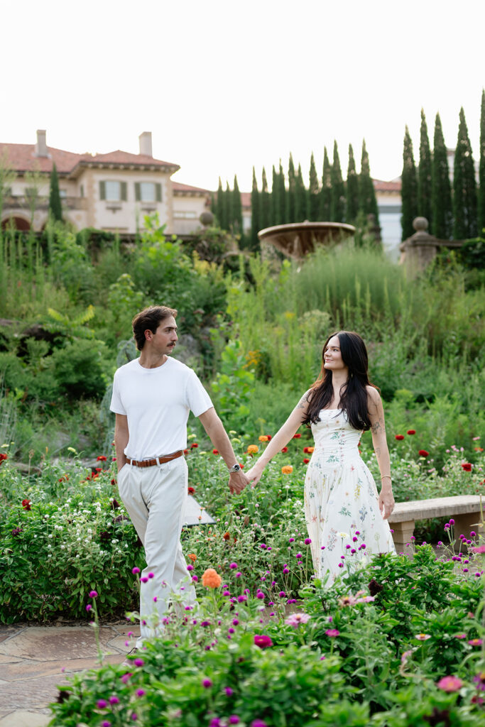 couple walking through the Philbrook gardens during engagement photos
